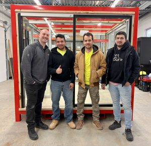 MetroWall installers standing in room with glass systems after certification and safety training.