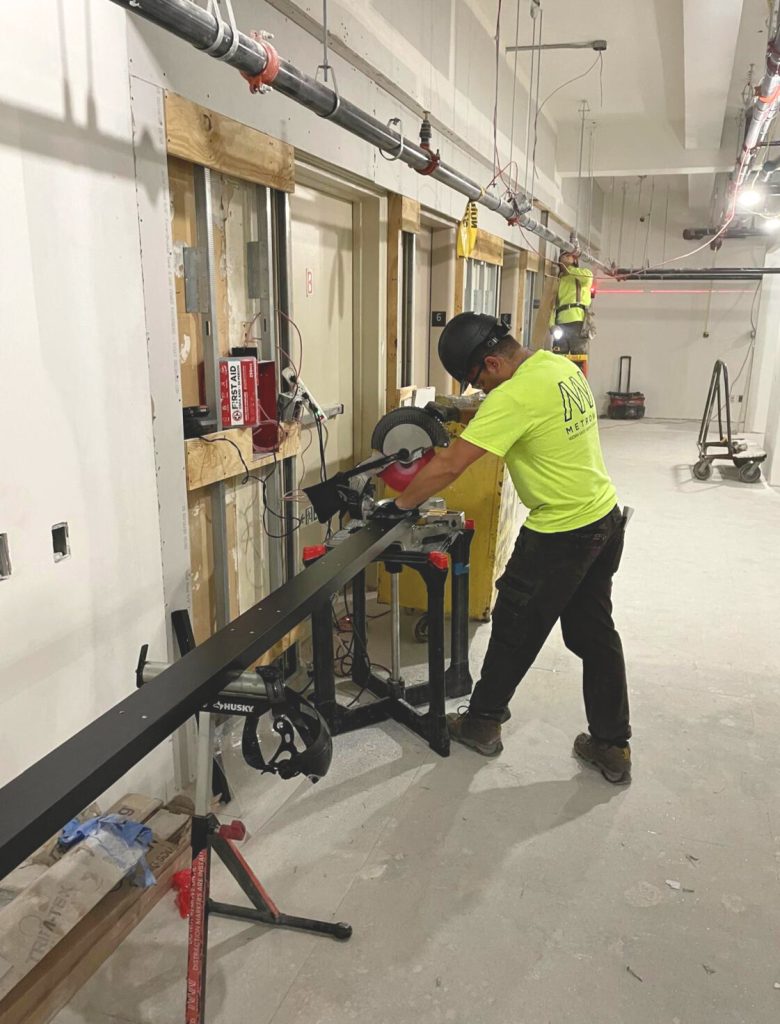 MetroWall installer cutting trim on-site.