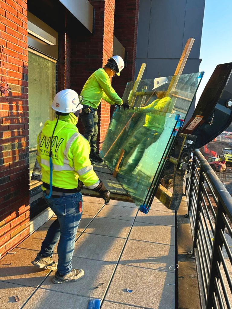 MetroWall installers using crane to get glass into commercial space.